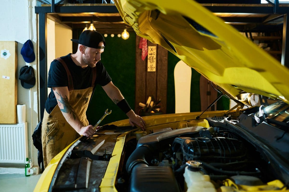 Mechanic inspecting a vehicle with its hood raised